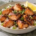 Maple glazed salmon bites served over rice with lemon and scallions